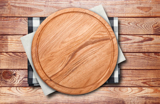 istock Empty vintage pizza board and napkin on planks. 1320929046
