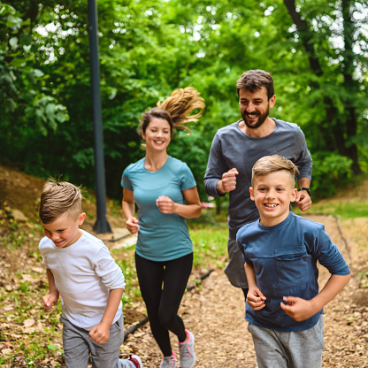 Portrait of happy family exercise running in the park spring time. Health care together love lifestyle concept