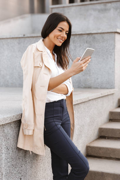 istock Smiling young woman using mobile phone 1320930219