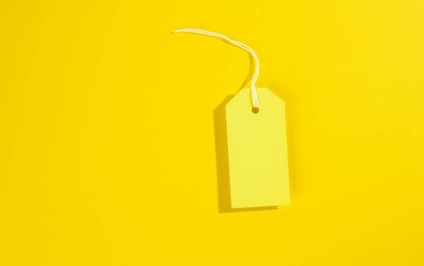 istock blank rectangular paper yellow price tag with white rope on yellow background 1320933861