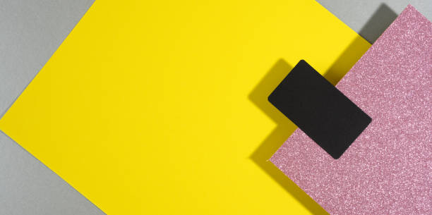 istock blank black rectangular business card on a creative background from sheets of paper with shadow, gray background and yellow sheets 1320934361