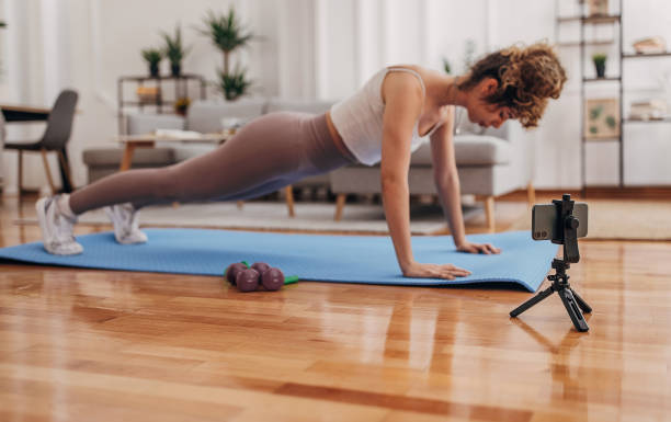 istock Female vlogger exercising at home 1320935203