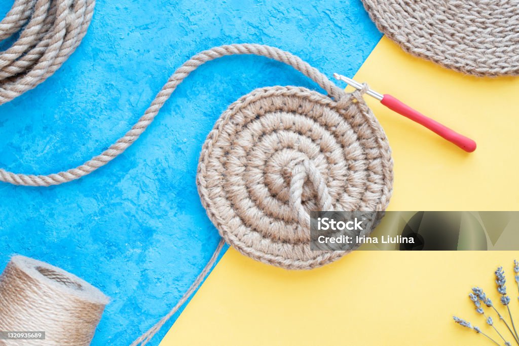 Knitting june basket on blue and yellow background, crochet, hobby knitting june basket on white and yellow background, hobby. Style flat lay. Jute crochet concept. Basket Stock Photo