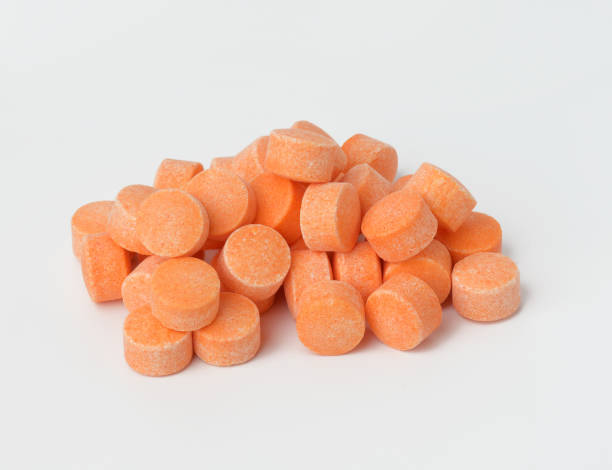 istock orange pills on white background, vitamin C, close up 1320935803