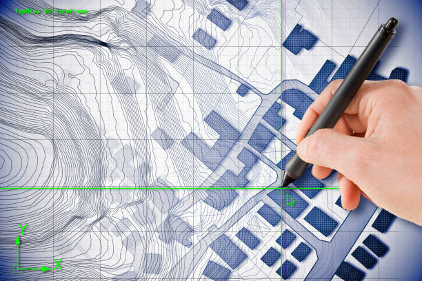 Architect drawing with a digital pen over an imaginary cadastral map of territory with buildings and roads drawn with a CAD (Computer-Aided-Design) computer software in dwg format file