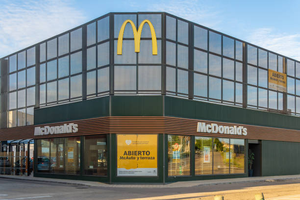 hauptfassade des fast-food-unternehmens mc donalds in der mallorinischen stadt manacor bei sonnenuntergang - city chicken stock-fotos und bilder
