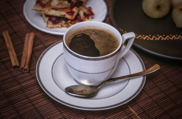 natura morta - una tazza calda di caffè nero, biscotti fatti in casa con frutta, mele al forno su un tappetino di bambù - fruit table bamboo black foto e immagini stock