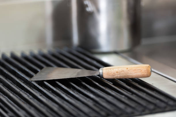 on the grill Put the putty knife on the grill in the kitchen. road scraper stock pictures, royalty-free photos & images