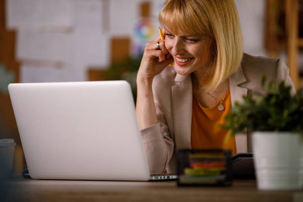 istock Smiling businesswoman using laptop while planning out a project 1320942788