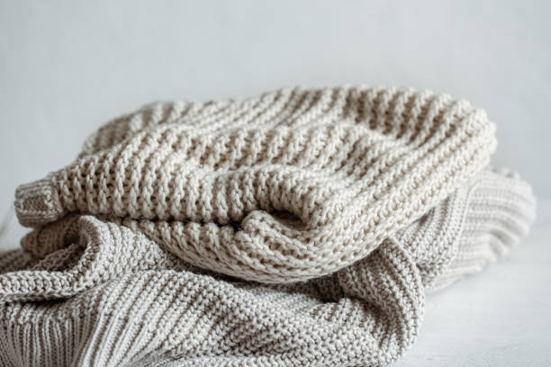 istock Cozy and warm knitted sweaters in pastel colors close-up. 1320943205