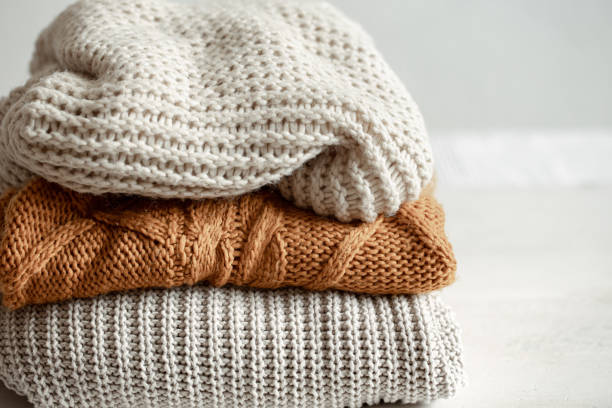 istock A stack of warm knitted sweathers on blurred background. 1320943415