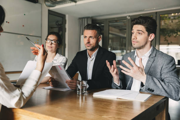 istock Business, career and placement concept - three executive directors or head managers sitting at table in office, and negotiating with new personnel during interview 1320943837