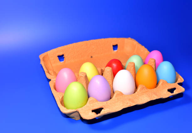 istock Easter eggs in a paperboard. Multi-colored eggs in egg carton on blue background 1320945868
