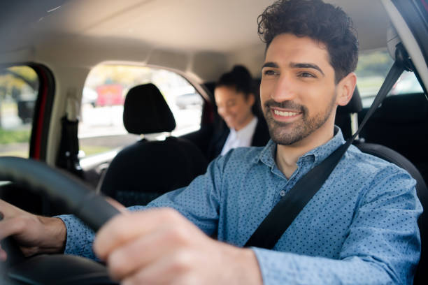 istock Taxi driver with passenger at back seat. 1320946435
