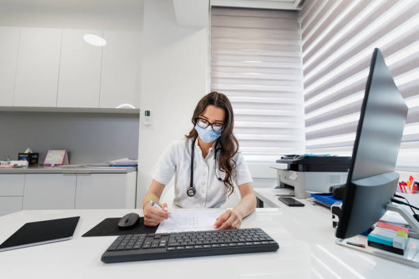 istock Female doctor wearing protective face mask analyzing test results in her office 1320947422