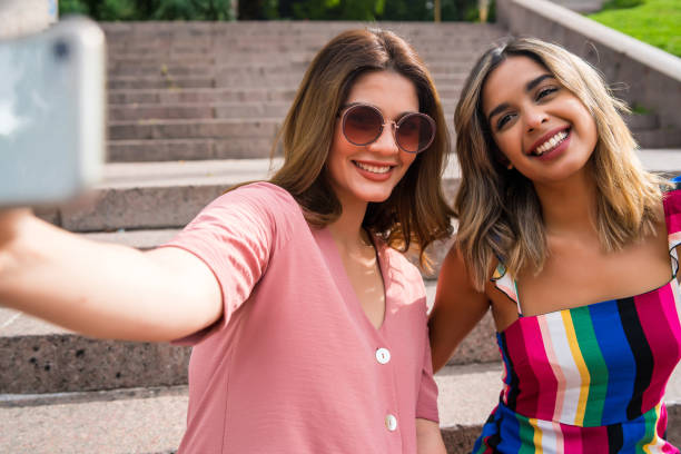 istock Two friends taking selfie with phone outdoors. 1320947685