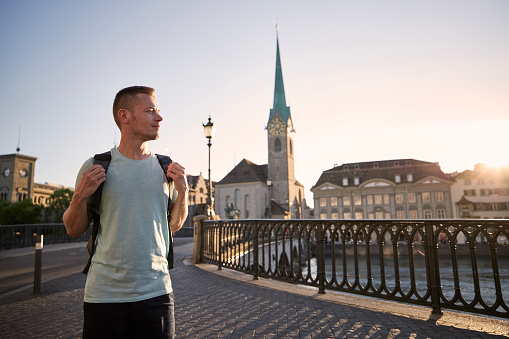 Man walking against cityscape of old town at beautiful sunset. Zurich, Switzerland.