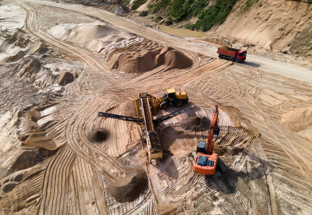 istock Arial view of the sand open-pit mining with heavy mining machinery. Mobile stone jaw crusher machine in open pit mine. 1320950299