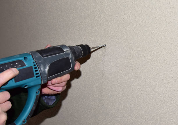 istock A drill with a drill drills a hole in a concrete wall 1320950304