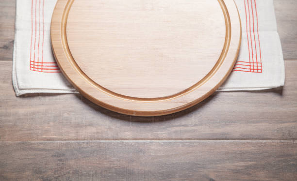 istock Empty pizza board and fabric tablecloth on the wooden background. 1320950327