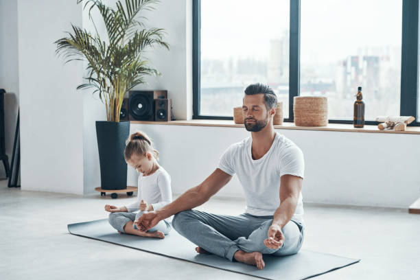 istock Father and daughter doing yoga 1320950565