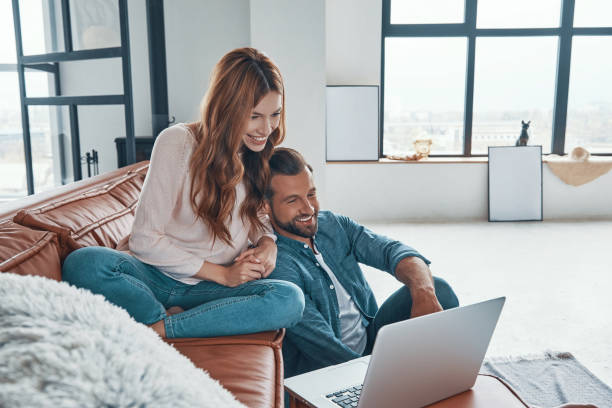 istock Loving young couple using laptop and smiling 1320950997