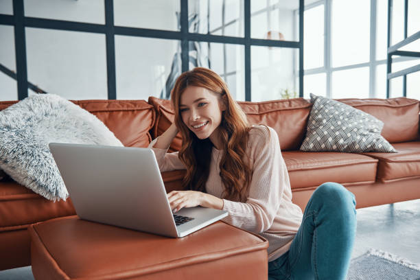 istock Attractive young woman using laptop and smiling 1320951011