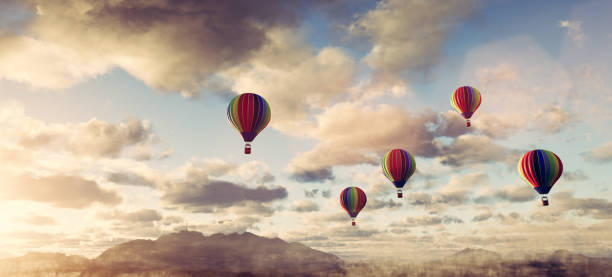 istock Hot air balloons flying above clouds at sunset 1320951092