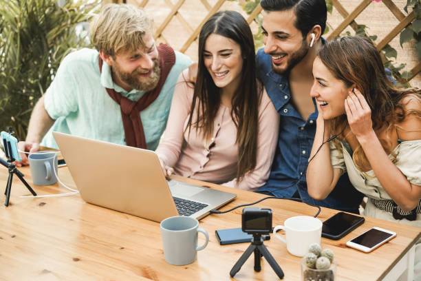 istock Young people streaming online using laptop computer and mobile phone camera outdoor at restaurant - Focus on right woman face 1320951700