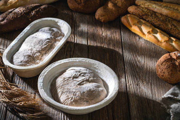 banneton panier pâte à pain au levain boulangerie fermentation avec pain pain sur bois - bread bread basket basket whole wheat photos et images de collection