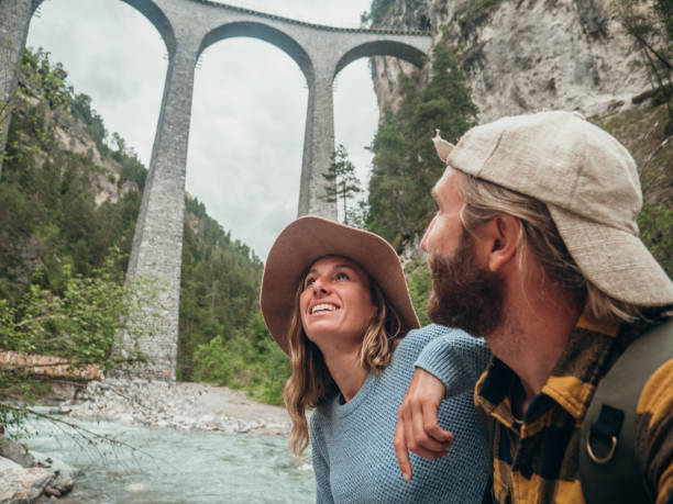 istock Couple contemplate viaduct from the river below, Switzerland 1320955398