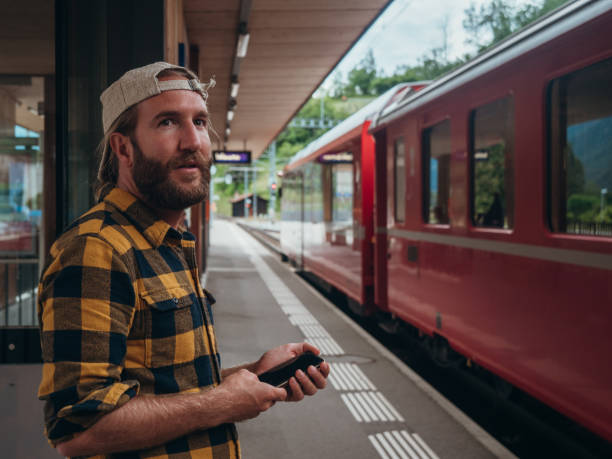 istock Man checks phone at train station 1320955972