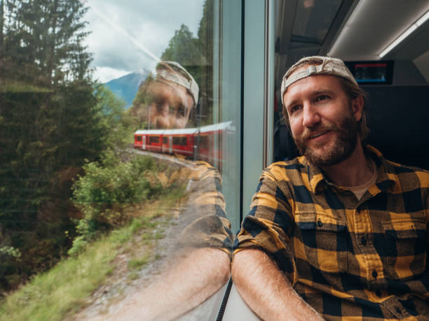 istock Man traveling by train looking from the window enjoying passing scenery 1320956053