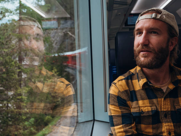 istock Man traveling by train looking from the window enjoying passing scenery 1320956141