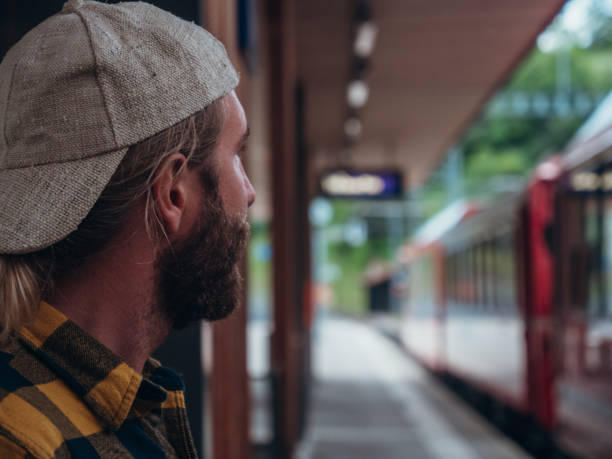 istock Man waits for train at station 1320956215