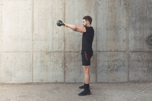 istock Young male athlete performing kettlebell swing 1320958123