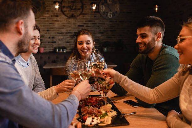 istock Group of young friends having fun in restaurant, talking and laughing while dining at table. 1320958177