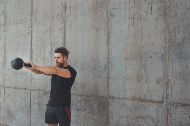 istock Young male athlete performing kettlebell swing 1320958181