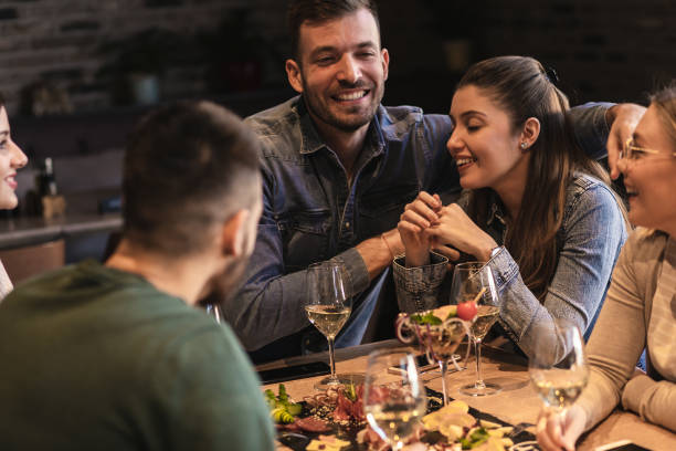 istock Group of young friends having fun in restaurant, talking and laughing while dining at table. 1320958214