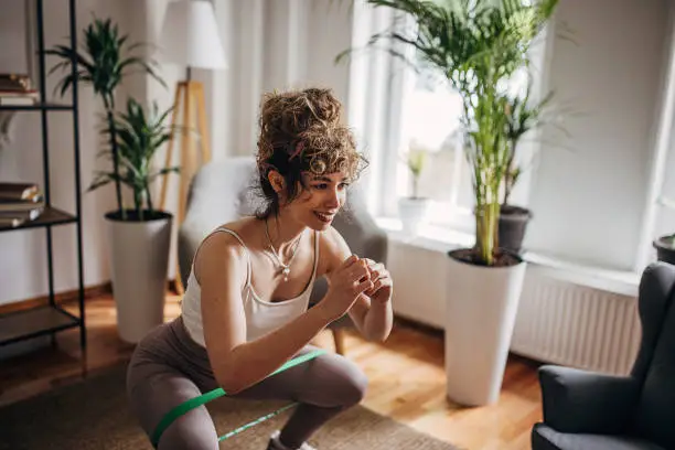 One woman, beautiful young sporty woman exercising on the floor in living room at home.