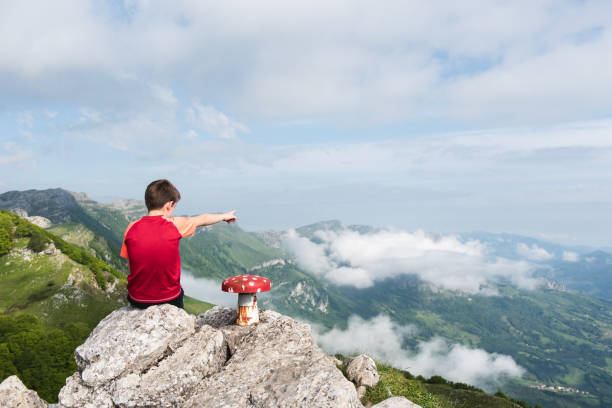 Boy pointing to infinity at the top of a mountain. Ttutturre summit, at the Aralar natural park, in Navarra, North of Spain.