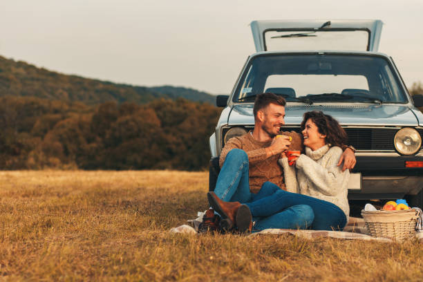 hermosa pareja joven disfrutando de tiempo de picnic en la puesta de sol - heterosexual couple love romance couple fotografías e imágenes de stock