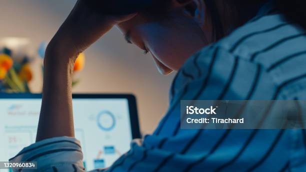 Young Asian Lady Employee Work Overtime Late Night Stress Finance Accounting Project Research On Laptop At Home Stock Photo - Download Image Now