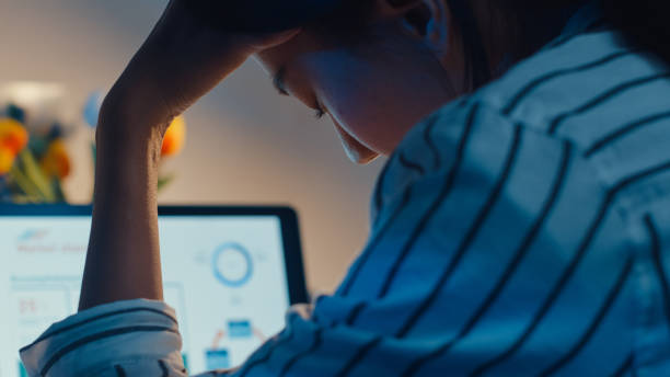 jovem funcionária asiática trabalha horas extras tarde da noite estresse finanças pesquisa projeto de contabilidade em laptop em casa. - business struggle - fotografias e filmes do acervo