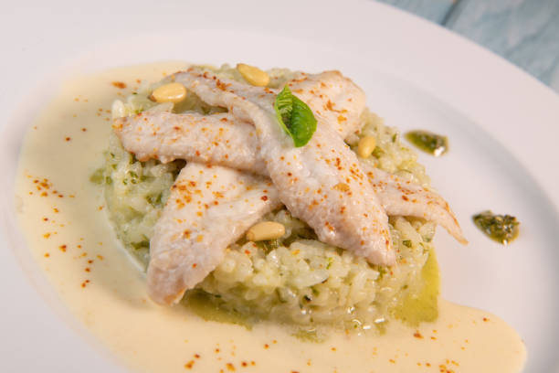 Baked sole fillet, risotto and pesto recipe. High quality photo