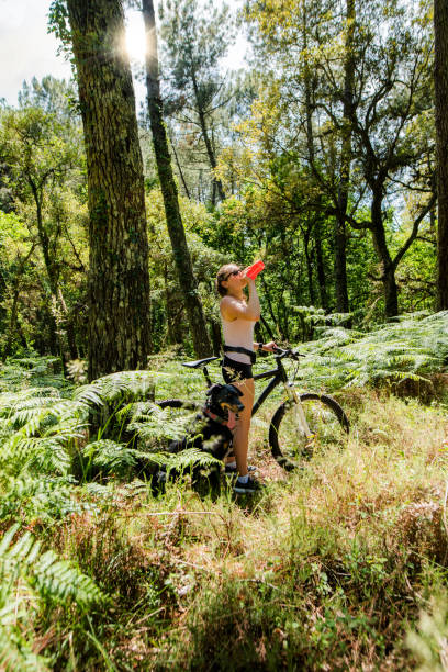 istock pretty young sporty woman hydrating herself while drinking her gourd 1320963012