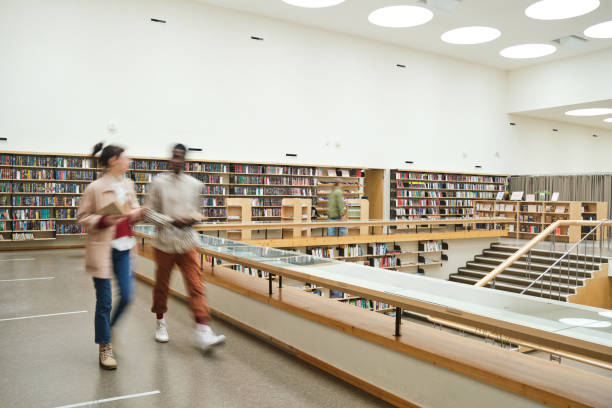 People in the big library Blurred motion of people walking along the corridor in big library college education stock pictures, royalty-free photos & images