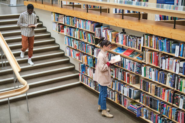 persone in biblioteca - smart casual women full length casual foto e immagini stock