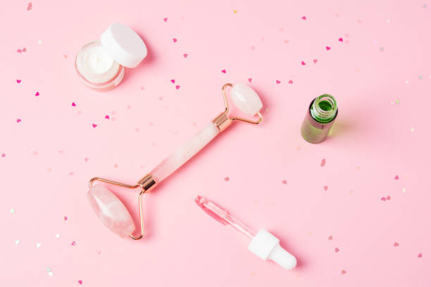 istock Massage quartz roller and dropper with cosmetic product on pink background 1320964711