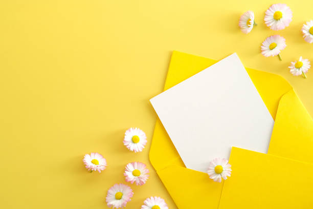 istock Open yellow envelope with white paper card mockup and chamomiles flowers on yellow background. Flat lay, top view, copy space. Greeting card for Mother's Day, Birthday, Women's Day 1320968199